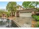 Two-story home with a large garage and desert landscaping in front at 9893 Santa Ponsa Ct, Las Vegas, NV 89178