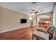 Open living room with hardwood floors, a ceiling fan, and an archway leading to other living areas at 9893 Santa Ponsa Ct, Las Vegas, NV 89178