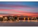 Beautiful home featuring a three-car garage, well-maintained landscaping, and a stunning colorful sunset sky at , Las Vegas, NV 89113