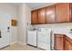 Laundry room features white appliances, wooden cabinets, and tiled floor at , Las Vegas, NV 89113