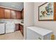 Laundry room with white washer, dryer, deep freezer, and wooden cabinets at , Las Vegas, NV 89113