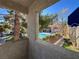 Balcony view overlooking the serene pool, framed by lush greenery and a stucco wall at 101 Luna Way # 222, Las Vegas, NV 89145