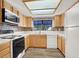Bright kitchen with white appliances, wooden cabinets, a skylight, and mosaic backsplash at 101 Luna Way # 222, Las Vegas, NV 89145