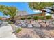 Community entrance featuring a stone wall, landscaped bushes and 'Arbor Ridge' sign at 1033 Logan Patrick Dr, Henderson, NV 89052