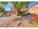 A beautifully landscaped front yard with gravel and colorful plants around a two-story home at 1033 Logan Patrick Dr, Henderson, NV 89052