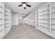 The bright loft area features built-in bookshelves, neutral carpet and a ceiling fan at 1033 Logan Patrick Dr, Henderson, NV 89052