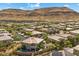 Community aerial showing desert landscape, multiple residences, green lawns, and houses with swimming pools at 10470 Dove Meadow Way, Las Vegas, NV 89135