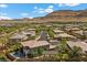 Community aerial showcasing desert landscape, residences, and green lawns in a serene, suburban setting at 10470 Dove Meadow Way, Las Vegas, NV 89135