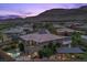 Expansive aerial view captures a luxurious home, sparkling pool, and covered patio against a backdrop of scenic mountains at 10470 Dove Meadow Way, Las Vegas, NV 89135