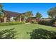 Spacious backyard featuring lush green turf and manicured landscaping with a covered patio at 10470 Dove Meadow Way, Las Vegas, NV 89135