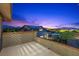 A cozy balcony with black metal railing, offering an outdoor space for relaxation and beautiful sunset views at 10470 Dove Meadow Way, Las Vegas, NV 89135