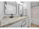 Modern bathroom featuring double sinks with granite countertops, white cabinets, and black hardware at 10470 Dove Meadow Way, Las Vegas, NV 89135