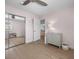 Bright bedroom featuring pale pink walls, modern light fixture, and mirrored closet at 10470 Dove Meadow Way, Las Vegas, NV 89135