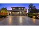 Elegant two-story home showcasing a three-car garage, stone accents, and a well-maintained brick driveway at 10470 Dove Meadow Way, Las Vegas, NV 89135