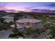 Stunning two-story home with a red tiled roof, well-kept landscaping, and a beautiful sunset backdrop at 10470 Dove Meadow Way, Las Vegas, NV 89135