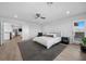 Bright main bedroom with a ceiling fan, large windows with shutters, stylish décor, and wood-look flooring at 10470 Dove Meadow Way, Las Vegas, NV 89135