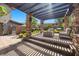 Inviting covered outdoor patio with stone pillars, a fire pit, and comfortable seating for relaxing and entertaining at 10470 Dove Meadow Way, Las Vegas, NV 89135