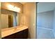 Well lit bathroom features a large mirror, spacious vanity, and a view into the bedroom at 11416 Belmont Lake Dr # 102, Las Vegas, NV 89135