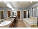 Spacious bathroom with dual vanities, granite countertops, a soaking tub, and a glass shower at 11416 Belmont Lake Dr # 102, Las Vegas, NV 89135