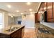 Bright kitchen with granite island, wood cabinets, stainless appliances, flowing into living room with fireplace at 11416 Belmont Lake Dr # 102, Las Vegas, NV 89135