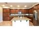 Gourmet kitchen featuring custom wood cabinets, granite countertops, stainless steel appliances, and a central island at 11416 Belmont Lake Dr # 102, Las Vegas, NV 89135