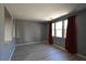 Sunlit living room featuring vinyl plank floors, neutral paint, and large windows with curtains at 11416 Belmont Lake Dr # 102, Las Vegas, NV 89135