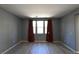 Spacious living room featuring vinyl plank floors, neutral paint, and large windows with curtains at 11416 Belmont Lake Dr # 102, Las Vegas, NV 89135