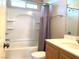 Bright bathroom with a shower-tub combo, shower curtain, and a wood-framed vanity with sink at 1152 Paradise Desert Ave, Henderson, NV 89002