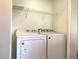 Bright laundry area featuring a side-by-side washer and dryer and wire shelving for organization at 1152 Paradise Desert Ave, Henderson, NV 89002