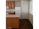 Kitchen featuring wood cabinets, laminate counters, white appliances, and wood laminate floors at 11882 Snow Bank St, Las Vegas, NV 89183