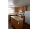 Kitchen featuring wood cabinets, laminate counters, white appliances, wood laminate floors, and an island at 11882 Snow Bank St, Las Vegas, NV 89183