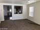 Open-concept living room with neutral paint, carpet floors, window, and views of the kitchen at 11882 Snow Bank St, Las Vegas, NV 89183