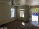 Bright living room featuring neutral paint, carpet floors, ceiling fan, and access to a window and the front door at 11882 Snow Bank St, Las Vegas, NV 89183