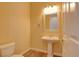 Powder room with pedestal sink, tiled floor, and warm neutral color scheme at 153 Cascade Lake St, Las Vegas, NV 89148