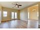 Bright living room features a ceiling fan, wood floors, and double doors leading to the backyard at 153 Cascade Lake St, Las Vegas, NV 89148