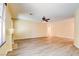 Spacious living room featuring wood-look flooring, a ceiling fan, and a cozy fireplace at 153 Cascade Lake St, Las Vegas, NV 89148