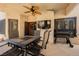 Relaxing covered patio area with dining set, ceiling fan, and mounted TV for outdoor entertaining at 2008 Spruce Brook Dr, Henderson, NV 89074