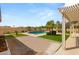Beautiful backyard with a refreshing pool, mature palm trees, and low-maintenance artificial turf, perfect for outdoor living at 215 Great Gable Dr, Las Vegas, NV 89183
