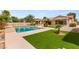 Expansive backyard features a sparkling pool, lush landscaping, and a covered patio, creating an ideal outdoor retreat at 215 Great Gable Dr, Las Vegas, NV 89183