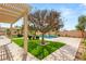 Lush backyard featuring a sparkling pool, mature trees and artificial grass under a covered patio, perfect for relaxation at 215 Great Gable Dr, Las Vegas, NV 89183