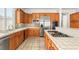 Well-lit kitchen features stainless steel appliances, tiled countertops and backsplash, and wooden cabinetry at 215 Great Gable Dr, Las Vegas, NV 89183