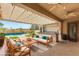 Inviting covered patio with comfortable seating and an outdoor kitchen, overlooking the sparkling pool and manicured lawn at 215 Great Gable Dr, Las Vegas, NV 89183