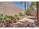 Private backyard features a well-maintained block wall with beautiful flower beds and desert landscaping at 2180 Polynesia Cir, Henderson, NV 89074