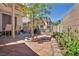 Backyard oasis with custom hardscape, lush desert landscaping, and cozy swing seating for serene relaxation at 2180 Polynesia Cir, Henderson, NV 89074