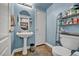 Powder room with pedestal sink, mirror, tile floors, and storage at 2180 Polynesia Cir, Henderson, NV 89074