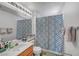 Bathroom with a wood vanity, large mirror, and shower with patterned curtain at 2180 Polynesia Cir, Henderson, NV 89074