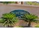 Entrance to Pacific Greens community featuring detailed sign with dolphin artwork, complemented by mature palms at 2180 Polynesia Cir, Henderson, NV 89074