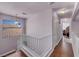Upstairs hallway with hardwood floors, white railing and a window at 2180 Polynesia Cir, Henderson, NV 89074
