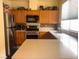 Well-lit kitchen with stainless steel appliances, island and wooden cabinetry at 2180 Polynesia Cir, Henderson, NV 89074