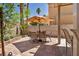 Enjoy outdoor dining on the spacious tiled patio with a large umbrella for shade and desert landscaping at 2180 Polynesia Cir, Henderson, NV 89074